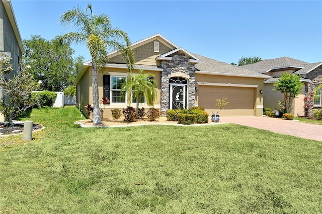 view of front of property with stucco siding, driveway, stone siding, a front yard, and a garage