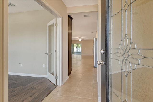 foyer featuring ceiling fan, baseboards, visible vents, and light tile patterned floors