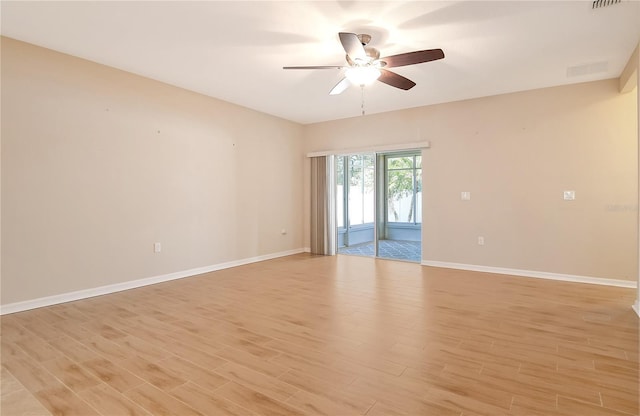 spare room with baseboards, a ceiling fan, visible vents, and light wood-type flooring