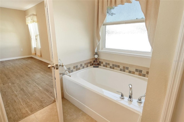 bathroom featuring a garden tub and tile patterned flooring
