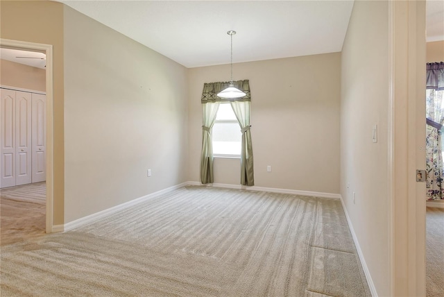 carpeted spare room featuring baseboards