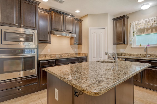kitchen featuring a sink, light tile patterned floors, black electric stovetop, under cabinet range hood, and light stone countertops