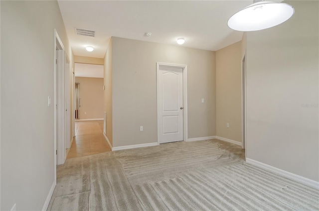 unfurnished room with light colored carpet, baseboards, and visible vents