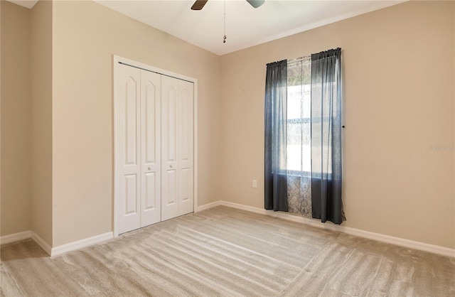 unfurnished bedroom featuring baseboards, carpet flooring, and a closet