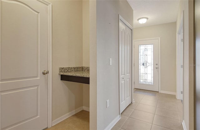 entrance foyer featuring light tile patterned flooring and baseboards