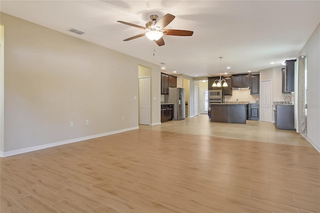 unfurnished living room with baseboards, visible vents, recessed lighting, light wood-style floors, and ceiling fan with notable chandelier