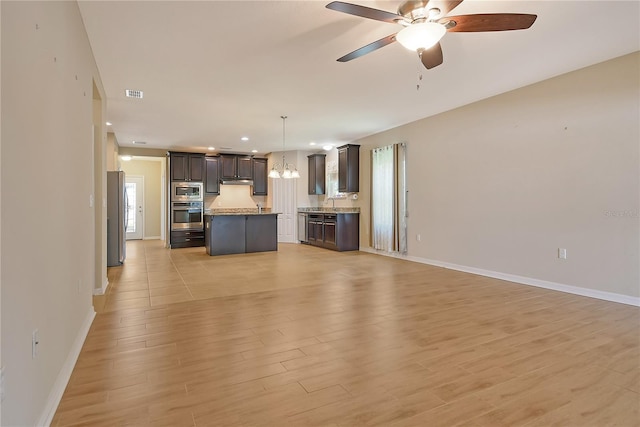 unfurnished living room with baseboards, recessed lighting, light wood-style floors, visible vents, and ceiling fan with notable chandelier
