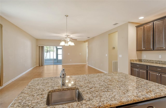 kitchen with dark brown cabinetry, a notable chandelier, a sink, and visible vents