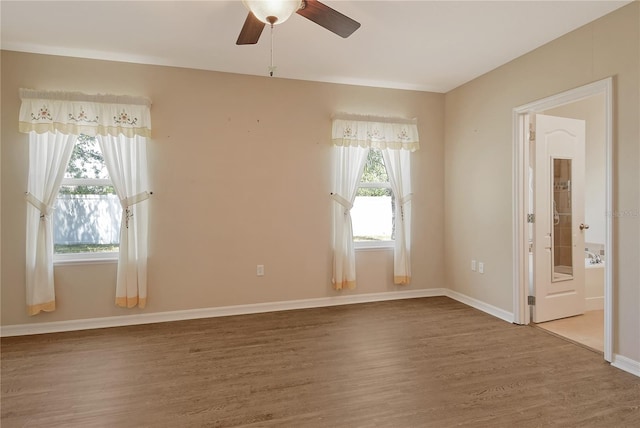 unfurnished room with ceiling fan, baseboards, and wood finished floors