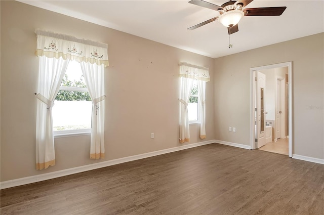 unfurnished bedroom with wood finished floors, ensuite bath, and baseboards