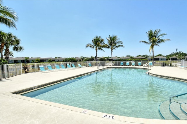 community pool with fence and a patio