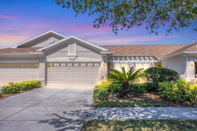 single story home featuring stucco siding, driveway, and a garage