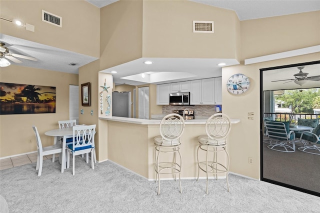 kitchen with stainless steel appliances, a ceiling fan, and visible vents