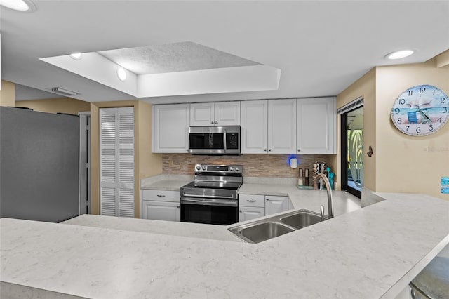 kitchen featuring stainless steel appliances, a sink, visible vents, decorative backsplash, and light countertops