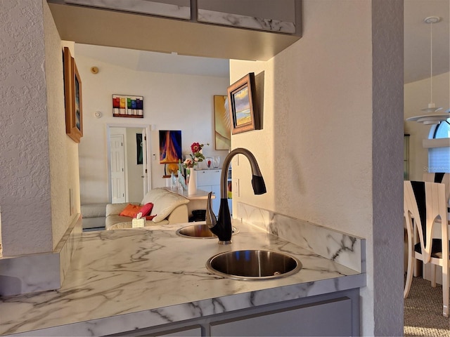 kitchen featuring a sink, light countertops, and a textured wall