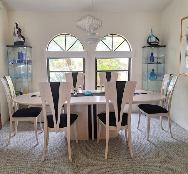 carpeted dining area with baseboards