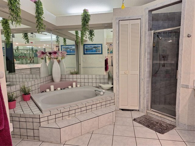 full bathroom with tile patterned flooring, a shower stall, a garden tub, and a closet