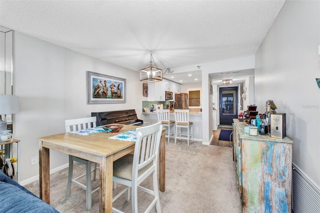 1701 Beach Rd Unit 305, Englewood, FL 34223 - dining room with light carpet, an inviting chandelier, baseboards, and a textured ceiling