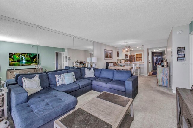 1701 Beach Rd Unit 305, Englewood, FL 34223 - living room featuring a notable chandelier, light carpet, and a textured ceiling