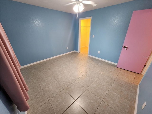 243 Harbor Blvd, Port Charlotte, FL 33954 - unfurnished bedroom with tile patterned floors, baseboards, a spacious closet, and ceiling fan