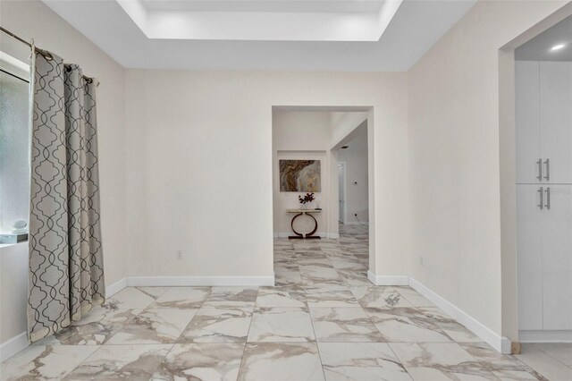 4213 Gardner Dr, Port Charlotte, FL 33952 - empty room with a tray ceiling, light marble finish floors, and baseboards
