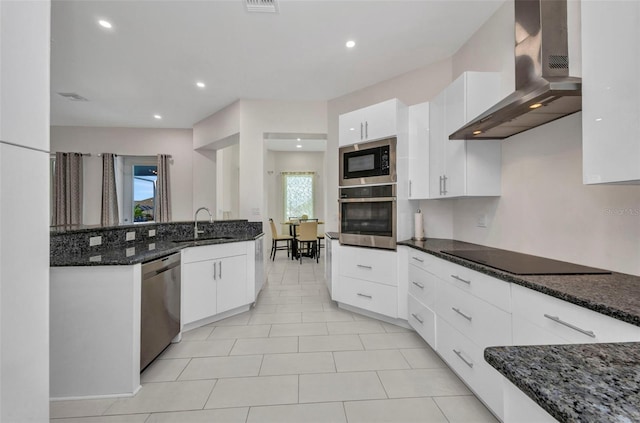4213 Gardner Dr, Port Charlotte, FL 33952 - kitchen featuring stainless steel appliances, wall chimney range hood, a sink, dark stone counters, and white cabinets