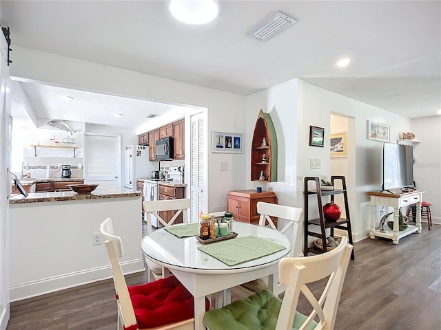 582 Ridgewood St NW, Port Charlotte, FL 33952 - dining space with dark wood-style flooring and baseboards