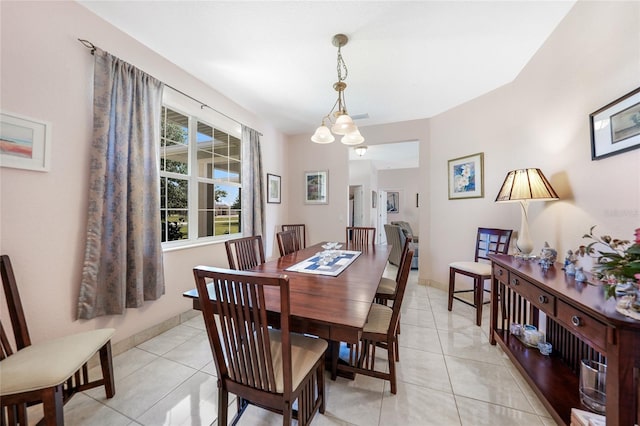 dining space featuring light tile patterned floors and baseboards