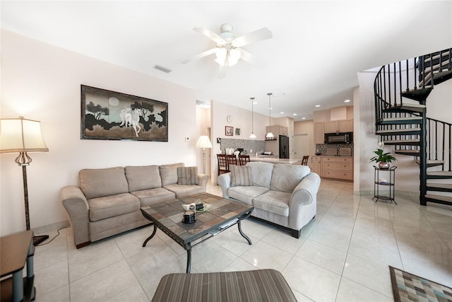 living room featuring stairway, a ceiling fan, and light tile patterned flooring