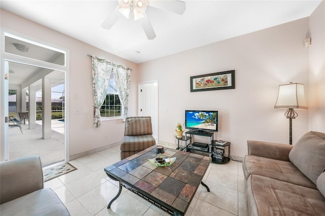 living room with a ceiling fan, light tile patterned flooring, and baseboards
