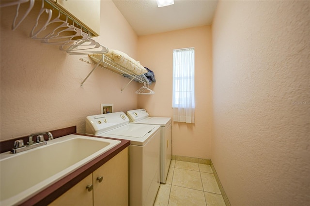 laundry room featuring independent washer and dryer, cabinet space, light tile patterned floors, and baseboards