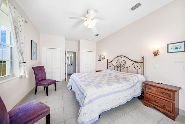 bedroom with multiple closets, light tile patterned floors, and a ceiling fan