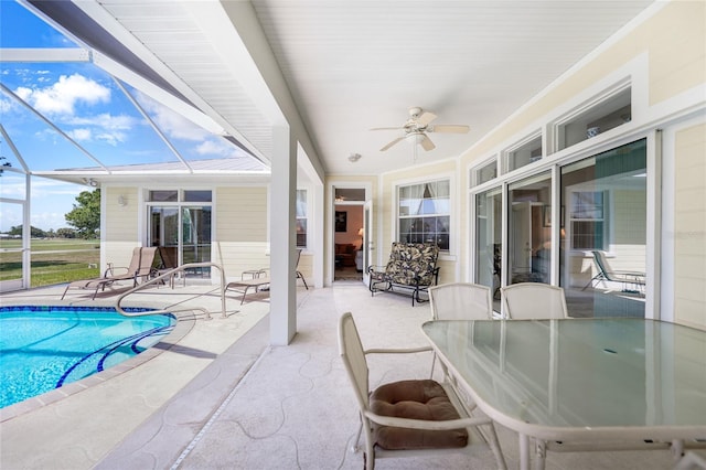 swimming pool featuring a patio, ceiling fan, and a lanai