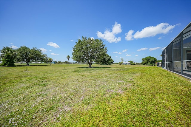 view of green lawn with glass enclosure
