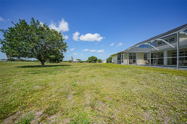 view of green lawn featuring a lanai