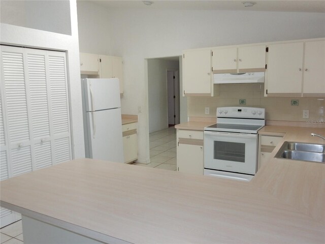582 Reading St NW, Port Charlotte, FL 33952 - kitchen featuring white appliances, under cabinet range hood, vaulted ceiling, light tile patterned floors, and tasteful backsplash