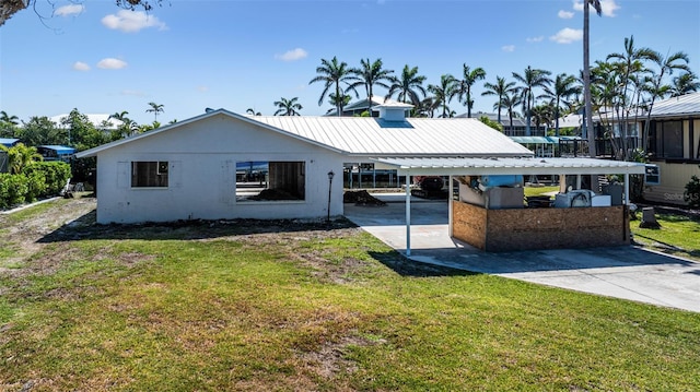 2560 Baybreeze St, Saint James City, FL 33956 - view of front of house featuring a carport, driveway, a front yard, and metal roof
