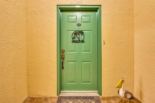 entrance to property featuring stucco siding
