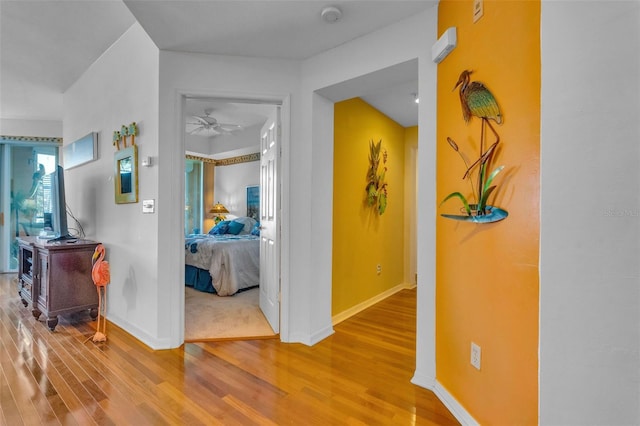 corridor with baseboards and wood finished floors