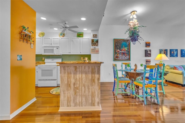 kitchen featuring a ceiling fan, backsplash, white cabinets, light wood finished floors, and white appliances