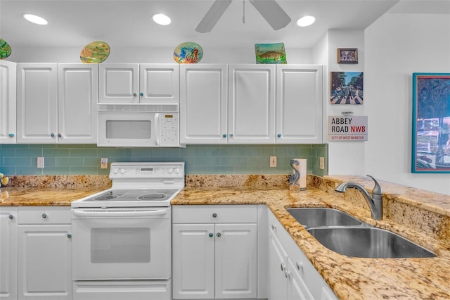 kitchen with white appliances, ceiling fan, white cabinetry, a sink, and backsplash