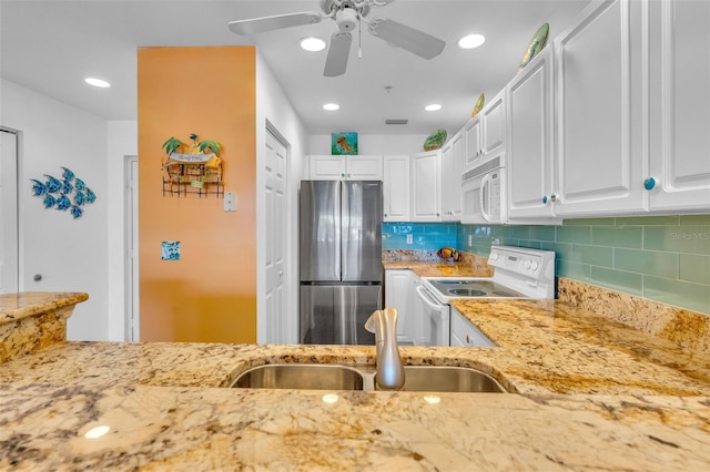 kitchen featuring white appliances, light stone countertops, and white cabinets
