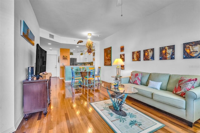 living room featuring baseboards, visible vents, and hardwood / wood-style floors