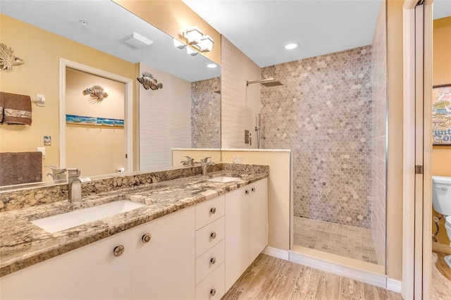 bathroom featuring a sink, walk in shower, toilet, and wood finished floors