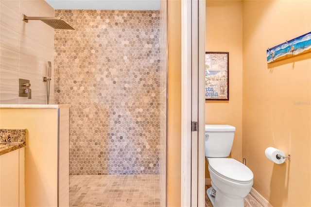 bathroom with toilet and tiled shower