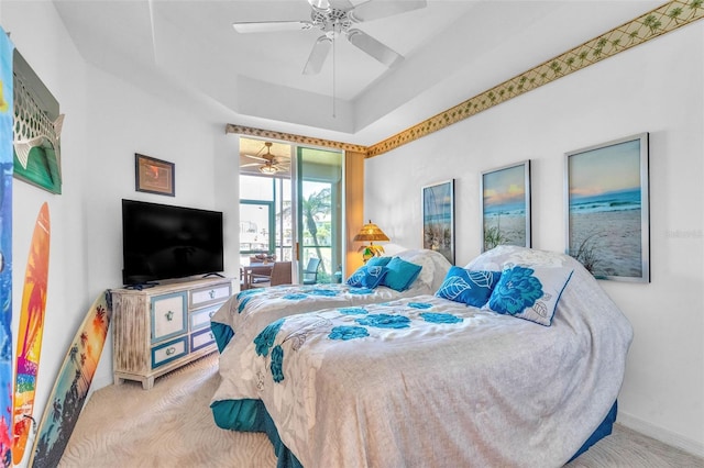 bedroom featuring baseboards, carpet flooring, a ceiling fan, and a tray ceiling