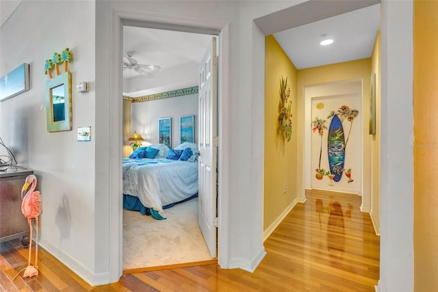 hall with light wood-type flooring and baseboards