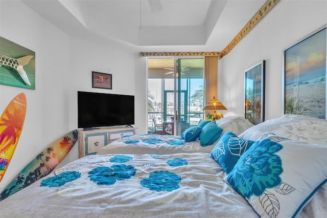 bedroom with a raised ceiling, access to outside, and ceiling fan