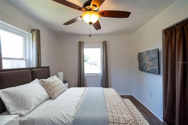 bedroom featuring dark wood-style floors, baseboards, and ceiling fan
