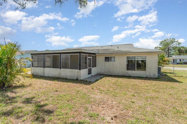 8238 San Jacinto Ave, North Port, FL 34287 - rear view of property featuring a sunroom, a lawn, stucco siding, and fence